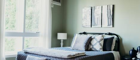 A bedroom with a bed, a nightstand, a lamp, and a ceiling fan.