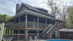A two-story house with a balcony, a pool, and a basketball hoop. - Six bedroom home with a hot tub, pool and an outdoor bar on a two acre lot. (Marquette)