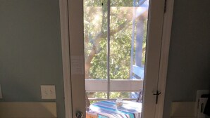 A compact kitchen with a view of outdoor furniture through a glass door. - Great Rates!  Screen Porch!  Pool Just Steps Away! (Seabrook Island)