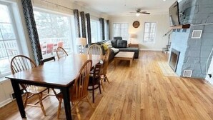 Amplia sala de estar con una mesa de comedor de madera, asientos cómodos y una chimenea.