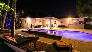 Ein Poolbereich mit Liegestühlen, einem kleinen Pool und einem Gebäude mit Terrasse.