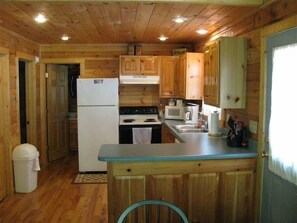 Effortlessly prepare meals in this well-equipped kitchen with a central island, refrigerator, stove, microwave, and coffee maker.