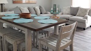 Un espace repas comprenant une table en bois, des chaises et un ventilateur de plafond.