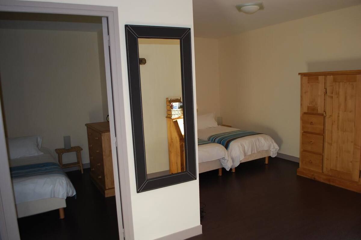 Une chambre à coucher avec un lit, une armoire en bois et un miroir au mur.