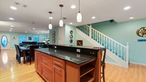 A spacious kitchen with a large island, wooden cabinets, and pendant lighting. - Sunbeam-Soundview Private Home. 2 Min Walk to the Beach (Navarre)