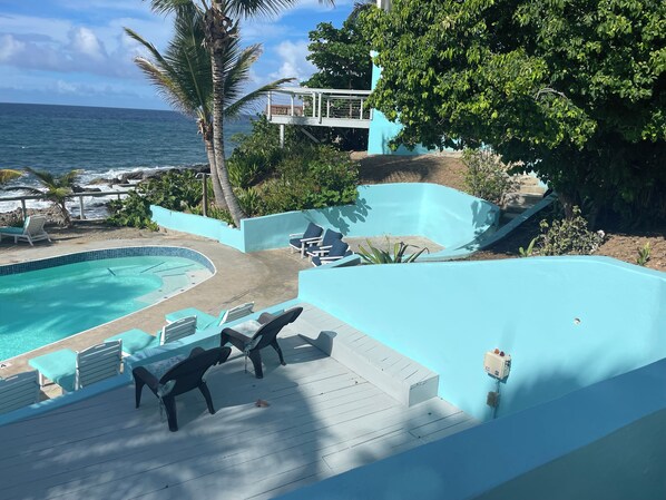 A pool area with lounge chairs and a view of the ocean. - OCEANFRONT!! WINDOWS BY THE SEA/St. Croix @SeaClusion/Cane Bay/1BR +/1BA USVI (Christiansted)