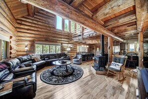 A log cabin interior with a large leather sofa, a round coffee table, and a fireplace. - Log Home Retreat, outdoor living w/ grill, pool table, 2mi to Ski & Main St. (Breckenridge)