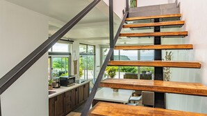 Een modern interieur met een trap, keuken en een eethoek.