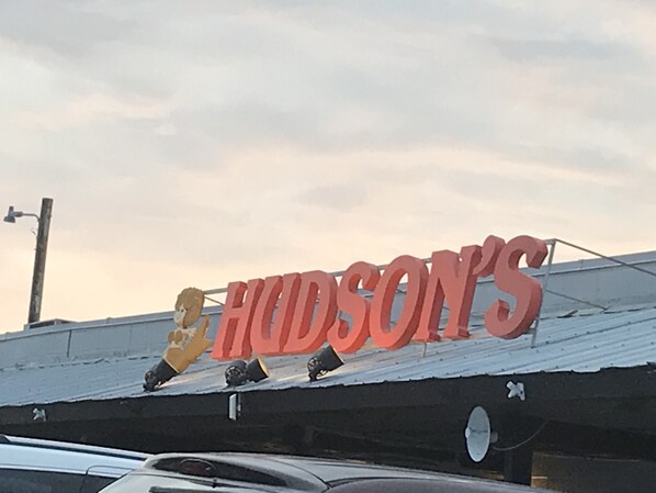 A building with a sign that reads "HUDSON'S" and a lion statue on the roof.