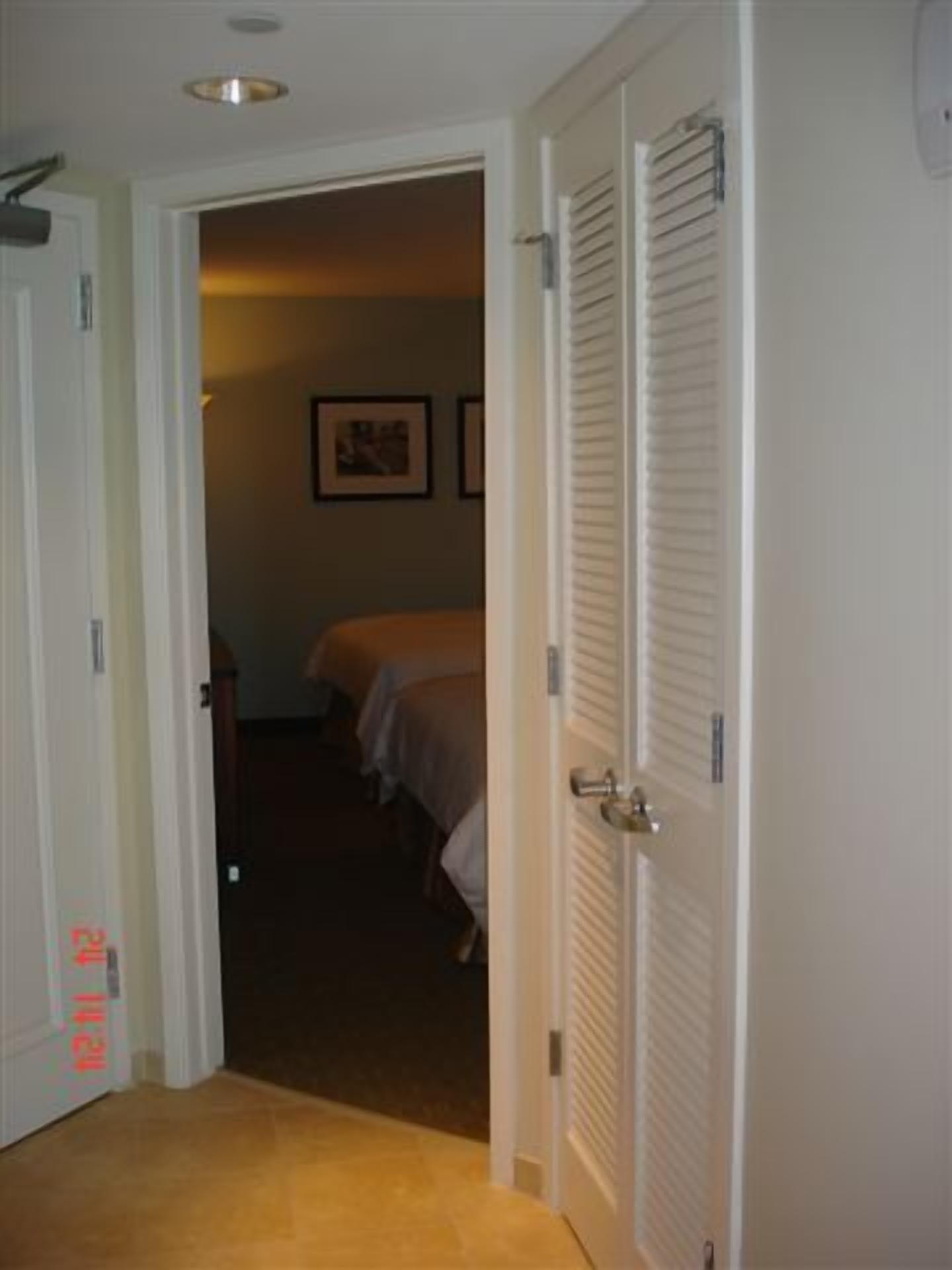 Ein Hotelzimmer mit geschlossener Tür, einem Bett und einem Nachttisch.