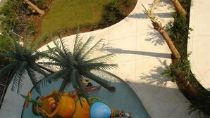 A children's play area with a slide, a palm tree, and a colorful play structure. - Myrtle Beach Oceanfront Condo. Sept. open Dates 79 a night. (Myrtle Beach)