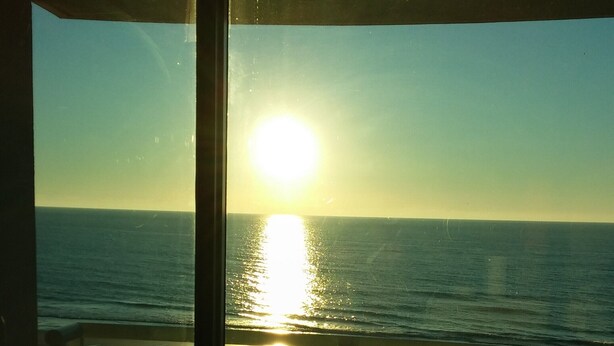 A view from a balcony overlooking a beach at sunset. - Myrtle Beach Oceanfront Condo. Sept. open Dates 79 a night. (Myrtle Beach)