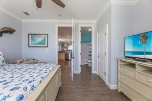 A bedroom with a bed, a television, and a hallway leading to a bathroom and kitchen. - Private 4/3 Pool Heater/Dock/Kayaks/Bikes,etc (Marathon)