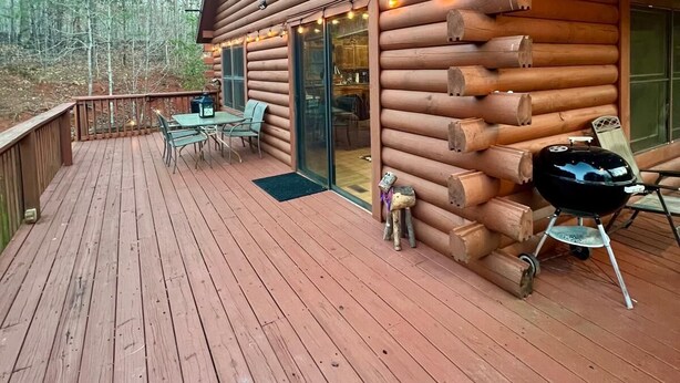 A log cabin with a deck, outdoor seating, and a grill. - Log Cabin On 5 Private Acres, Gated Community With River Access (Rutherfordton)