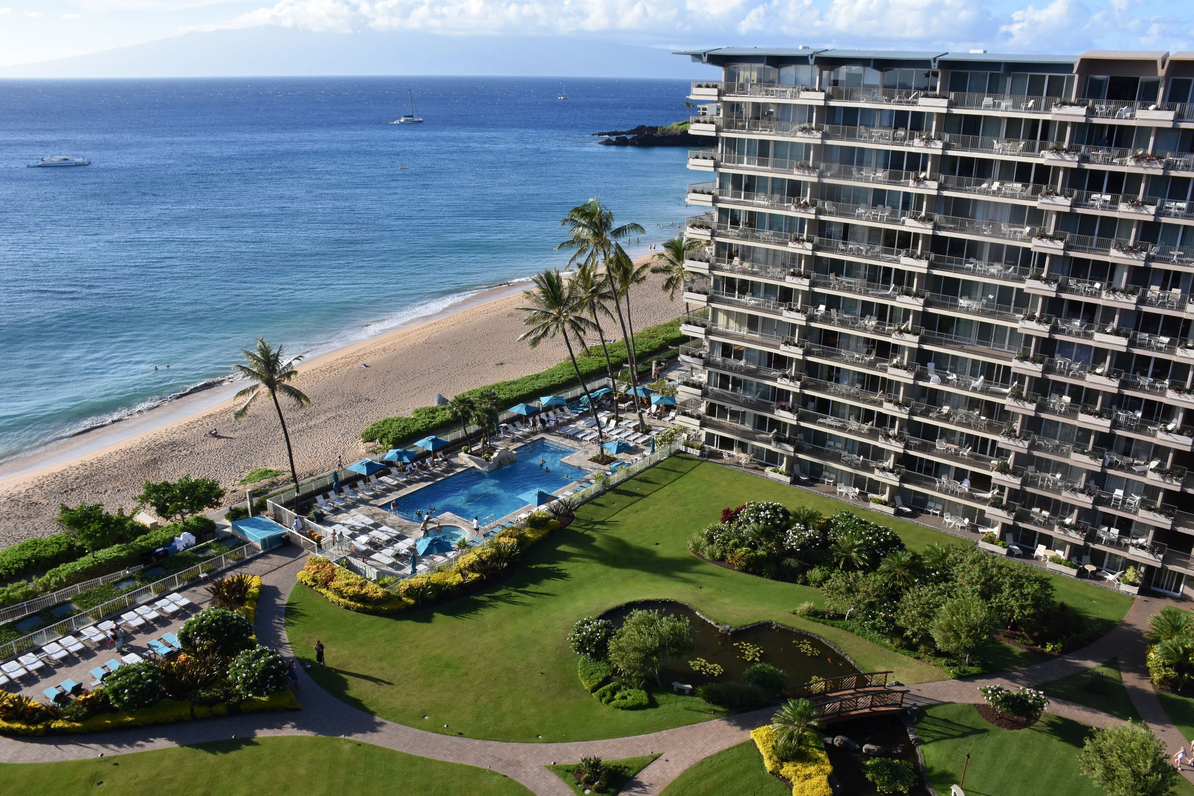 Un hôtel doté d’une piscine, offrant une vue sur la plage et comprenant plusieurs balcons.