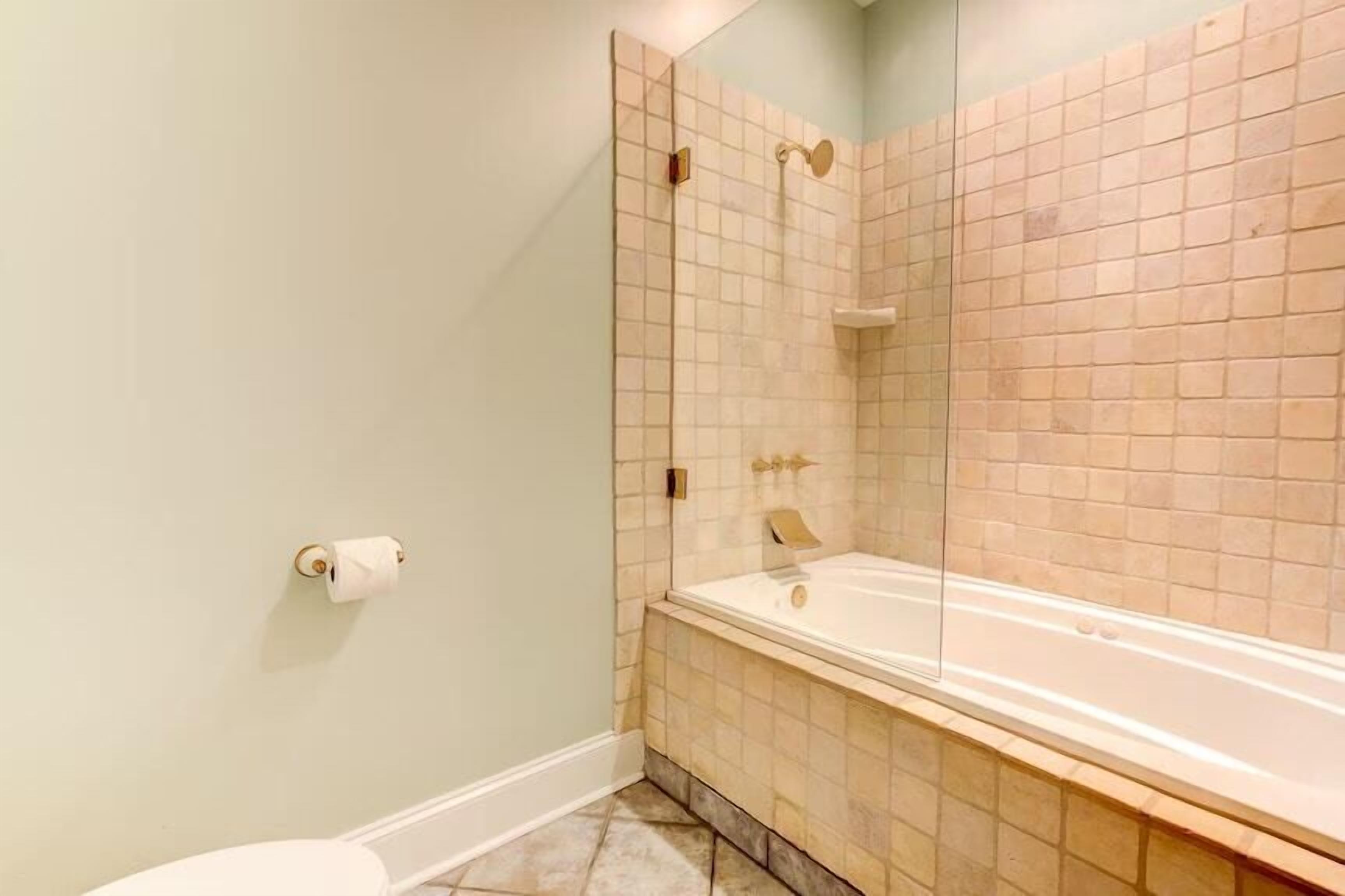 A bathroom with a toilet, a shower with a glass door, and a bathtub.