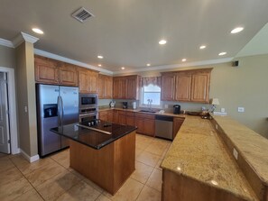 Large Kitchen, stocked with plenty of dishes, pot, pans and utensils 