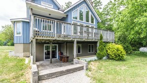 A two-story house with a balcony, a covered porch, and a small outdoor seating area. - Executive Blue Mountain Chalet, 6 Bedrooms, Sauna (Blue Mountains)