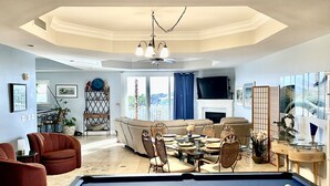 Una sala de estar con mesa de billar, sofá y comedor.