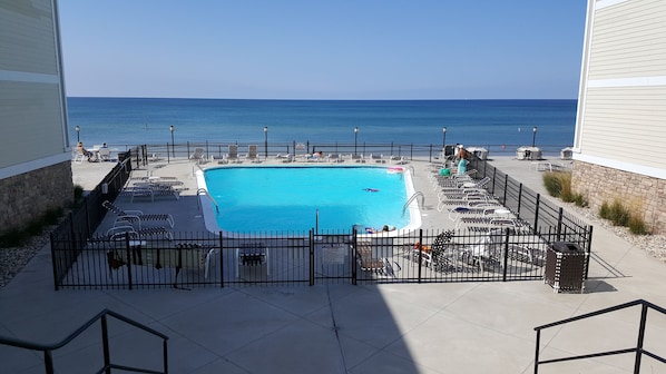 Relax by the ocean-view pool surrounded by lounge chairs and umbrellas.