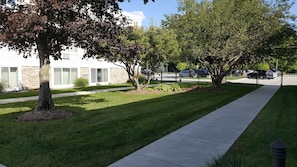 Stroll along the paved walkway to a charming row of homes with shutters and a peaceful atmosphere.