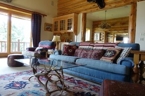 A cozy living room with a blue sofa, patterned rug, and wooden furniture.