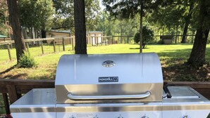 A stainless steel NEXGRILL barbecue grill with four burners, a side burner, and a lid, placed on a wooden deck. - Bargain housing Minutes from Tryon International Equestrian Center (Tryon)