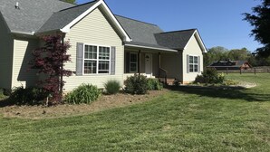 A single-story house with a gabled roof, a front porch, and a well-maintained lawn. - Bargain housing Minutes from Tryon International Equestrian Center (Tryon)