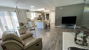 A modern living room with a leather sofa, a glass coffee table, and a flat-screen TV. - Bargain housing Minutes from Tryon International Equestrian Center (Tryon)