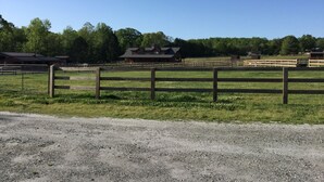 A rural property with a gravel driveway, wooden fences, and multiple barns. - Bargain housing Minutes from Tryon International Equestrian Center (Tryon)