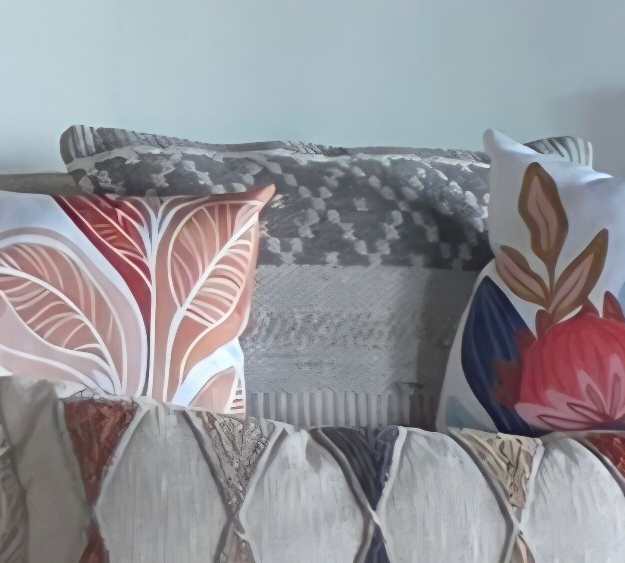 Ein Bett mit vielen Kissen, einer Decke und einer Wand mit strukturierter Oberfläche.