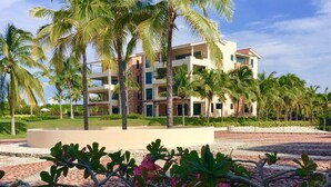 Ein Resort mit Palmen und einem mehrstöckigen Gebäude mit Balkonen.