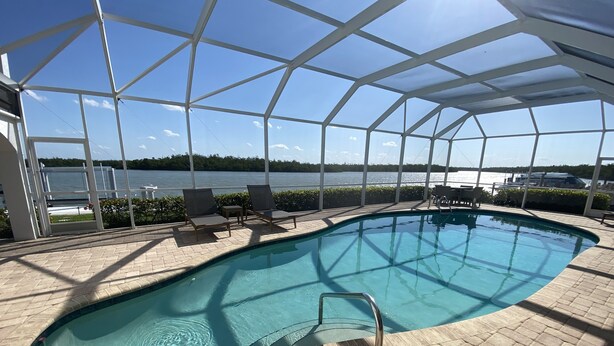 Piscina interna con vista sul lago e area coperta con sedie a sdraio.