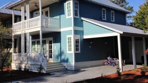 Une maison à deux étages avec un balcon, un garage et un vélo garé à l’extérieur.