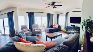 A spacious living room with a sofa, armchairs, a coffee table, and a television. - Pacific Ocean View in Pedregal- Mexican Chic 4 Bedroom Private Villa with Pool (Cabo San Lucas B.C.S)