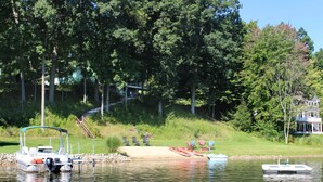 A lakeside property with a dock, boats, and a house with a deck. - Secluded Lake Retreat-Exceptional Reviews! (Dowling)