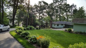 A residential property with a well-maintained lawn, a detached garage, and a small house with a chimney. - Secluded Lake Retreat-Exceptional Reviews! (Dowling)