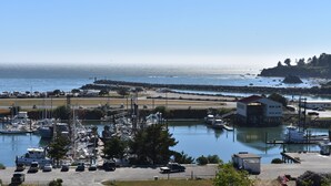 Un puerto deportivo con barcos amarrados, un pequeño edificio y una vista despejada del agua.