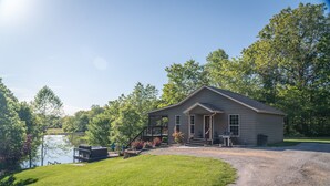 Eenlaags huis met een veranda, een terras en uitzicht op een meer.