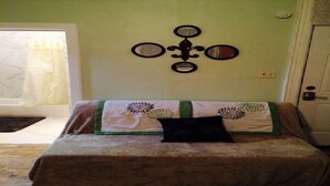 A room with a bed, a wall-mounted cross, and a door. - SPACIOUS AND OPEN PROPERTY W/KITCHEN - 3 MINUTES TO SUBWAY (New York)