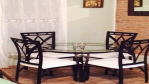 A round glass table with four black chairs with white cushions. - SPACIOUS AND OPEN PROPERTY W/KITCHEN - 3 MINUTES TO SUBWAY (New York)
