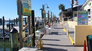 A boardwalk with signs for Harborwalk Marina, glass bottom boat, dolphin cruises, and a destination hotel with amenities like sea snorkeling, blaster cruise, and kayak rental. - BEACH COTTAGE 3BR , GOLF CART W/HOUSE, PORCH SWING ,POOL 30 STEPS AWAY, PETS LOV (Destin)