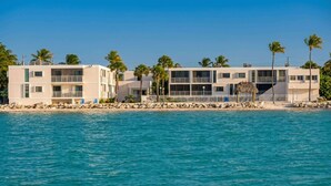 A beachfront hotel with multiple floors, balconies, and a pool area. - Oceanfront oasis beach views heated pool U34 (Marathon)