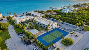 A residential area with a tennis court, parking, and a view of the ocean. - Oceanfront oasis beach views heated pool U34 (Marathon)