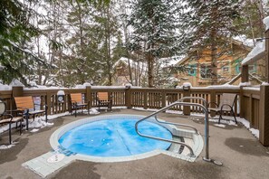 A pool area with a wooden deck, metal railings, and snow-covered trees in the background. - Spacious & Quiet Townhome Ideal Year-Round Location, Private Entrance (Whistler)