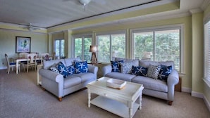 A living room with two sofas, a coffee table, and a ceiling fan.