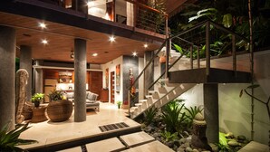 Ein modernes Interieur mit Treppe, Holzboden und Zimmerpflanzen.