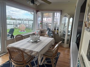 A dining area with a table set for four, a decorative bowl, and a view of the outdoors. - Fabulous Waterfront  Home. CLEARWATER BEACH. Bayfront. Large private dock (Clearwater Beach)