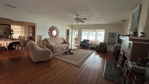 A spacious living room with a large sofa, a coffee table, and a dining area with chairs and a table.