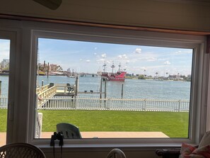 A view from a room with a large window overlooking a marina with boats and a grassy area. - Fabulous Waterfront  Home. CLEARWATER BEACH. Bayfront. Large private dock (Clearwater Beach)
